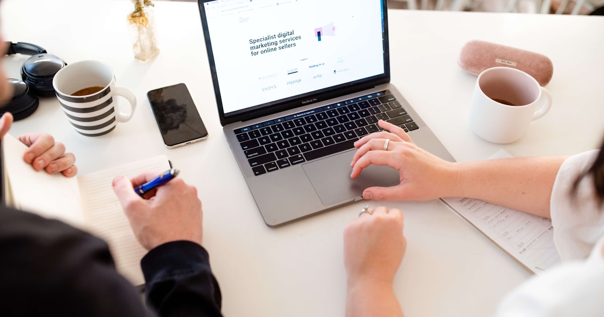 A marketing team working on a laptop together